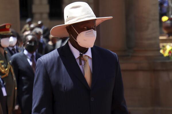 Ugandan President Yoweri Museveni, left, wearing a face mask in South Africa, Tuesday, Feb. 28, 2023. Uganda's long-time president says he is taking "forced leave" after testing positive for COVID-19. While two of three samples collected from him earlier in the week tested negative, one returned a positive result, he said in a statement Thursday. (AP Photo)