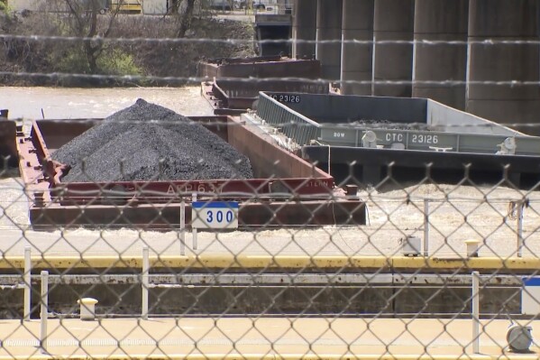 A group of barges sit pinned against the Emsworth lock and dam in Pittsburgh, on Saturday, April 13, 2024. More than two dozen river barges broke loose from their moorings and floated down the Ohio River, damaging a marina and striking a bridge. (WTAE via AP)