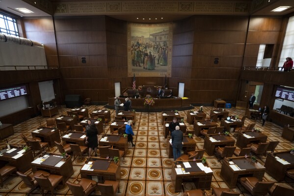 FILE - Members of the Oregon legislature are seen on the Senate floor during the first day of the legislative session at the Oregon State Capitol, Monday, Feb. 5, 2024, in Salem, Ore. Oregon lawmakers have passed a campaign finance reform bill that limits the amount of money people can donate to political candidates. Oregon is currently one of a dozen states that has no limits on campaign contributions. Under the bill, individuals and corporations could contribute just over $3,000 to a statewide candidate per election cycle. (AP Photo/Jenny Kane, File)