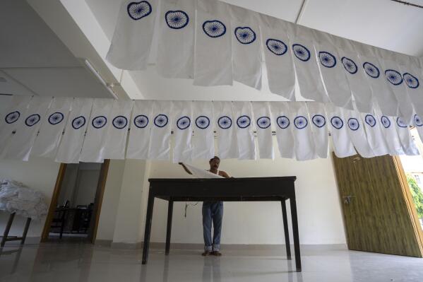 FILE- A man works on an under-production Indian national flag to dry in an office ahead of Independence Day in Gauhati, in the northeastern state of Assam, Aug. 2, 2022. India marks 75 years of independence from British rule on Aug. 15. (APPhoto/Anupam Nath, File)