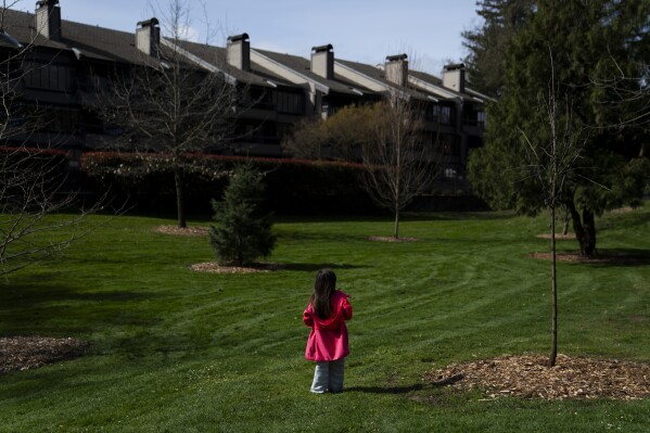 A homeless child plays in the park after receiving free food with her mother and sister, in Riverside Park, Thursday, March 21, 2024, in Grants Pass, Ore. (AP Photo/Jenny Kane)