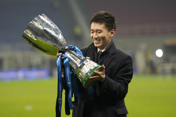 FILE - Inter Milan's President Steven Zhang smiles as he holds the trophy after winning the Italian Super Cup final soccer match between Inter Milan and Juventus at the San Siro Stadium, in Milan, Italy, Wednesday, Jan. 12, 2022. American fund Oaktree has officially become the new owner of Serie A champion Inter Milan. It brings an end to Suning and Steven Zhang's eight years at the helm. (AP Photo/Luca Bruno, File)