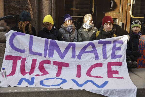 Climate activist Greta Thunberg, third from left, and other protesters, block the entrance of the Swedish Parliament during a climate protest in Stockholm, Sweden, Monday, March 11, 2024. (Christine Olsson/TT News Agency via AP)