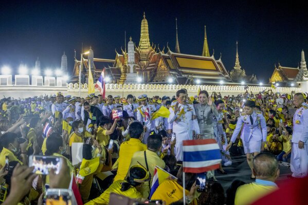 King Maha Vajiralongkorn, center left and Queen Suthida, center right wave to supporters in Bangkok, Thailand, Sunday, Nov. 1, 2020. Under increasing pressure from protesters demanding reforms to the monarchy, Thailand's king and queen met Sunday with thousands of adoring supporters in Bangkok, mixing with citizens in the street after attending a religious ceremony inside the Grand Palace. (AP Photo/Wason Wanichakorn)