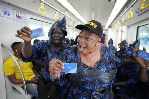 People sing as the ride on a new Lagos blue line train service in Lagos, Nigeria, Monday, Sept. 4, 2023. Lagos state government on Monday, began its 13km (9 miles) metro blue line services to the public . Officials say The Blue Line Rail is one of the rail projects designed to make Lagos a fully interconnected city and it will transform the city's transport system. (AP Photo/Sunday Alamba)