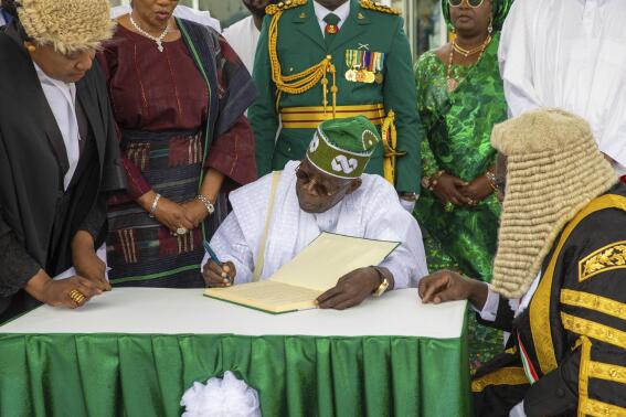 In this photo released by the Nigeria State House, Nigeria's new President Bola Ahmed Tinubu, signs a document after taking the oath of office at a ceremony in Abuja Nigeria, Monday May 29, 2023. Tinubu has been sworn in as president of Africa's most populous country at a period of unprecedented challenges, leaving some citizens hopeful for a better life and others skeptical that his government would perform better than the one he succeeded. (Sunday Aghaeze/Nigeria State House via AP)