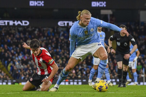 Manchester City's Erling Haaland, right, duels for the ball with Brentford's Christian Norgaard during the English Premier League soccer match between Manchester City and Brentford at the Etihad stadium in Manchester, England, Tuesday, Feb. 20, 2024. (AP Photo/Rui Vieira)