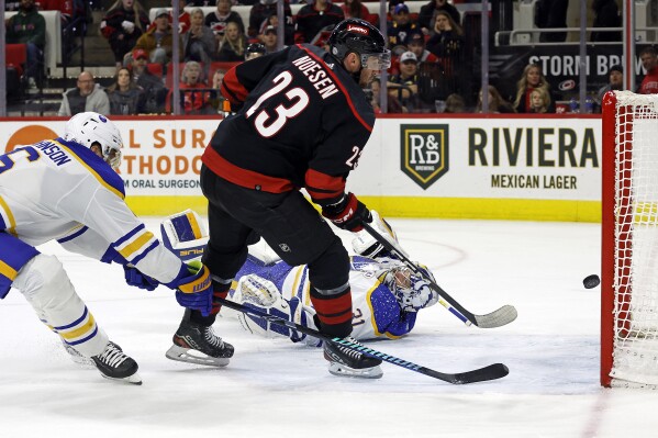Carolina Hurricanes' Stefan Noesen (23) flips the puck past Buffalo Sabres goaltender Eric Comrie (31) for a goal during the second period of an NHL hockey game in Raleigh, N.C., Saturday, Dec. 2, 2023. (AP Photo/Karl B DeBlaker)