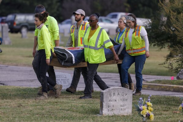 FILE - Researchers and burial oversight committee member Brenda Alford carry the first set of remains exhumed from the latest dig site in Oaklawn Cemetery to an onsite lab for further examination Wednesday, Sept. 13, 2023 in Tulsa, Okla. The latest search for remains of victims of the 1921 Tulsa Race Massacre has ended with 59 graves found and seven sets of remains exhumed. Oklahoma state archaeologist Kary Stackelbeck said excavation ended Friday, Sept. 29 with the exhumed remains taken to an onsite forensic laboratory to begin efforts to identify them and determine the causes of their deaths. (Mike Simons /Tulsa World via AP)