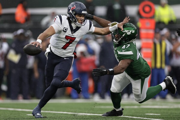 Houston Texans quarterback C.J. Stroud (7) rolls out of the pocket under pressure from New York Jets linebacker Bryce Huff (47) during the first quarter of an NFL football game, Sunday, Dec. 10, 2023, in East Rutherford, N.J. (AP Photo/Adam Hunger)