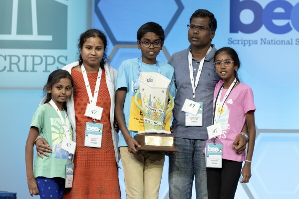 Bruhat Soma, 12, of Tampa, Fla., stands on stage with his family after winning the Scripps National Spelling Bee, in Oxon Hill, Md., Thursday, May 30, 2024. (AP Photo/Mariam Zuhaib)