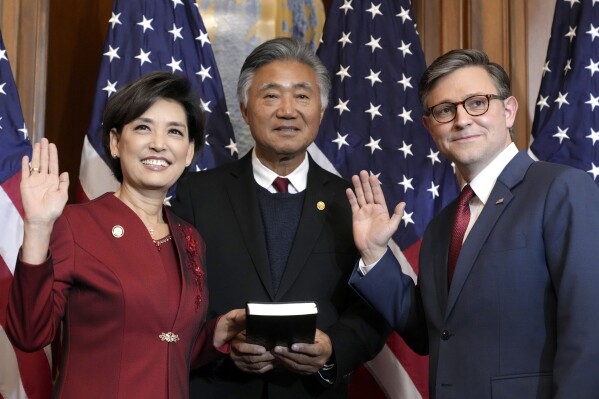 House Speaker Mike Johnson, R-La., right, poses during a ceremonial swearing-in with Rep. Young Kim, R-Calif., left, in the Rayburn Room at the Capitol in Washington, Friday, Jan. 3, 2025. (AP Photo/Jacquelyn Martin)