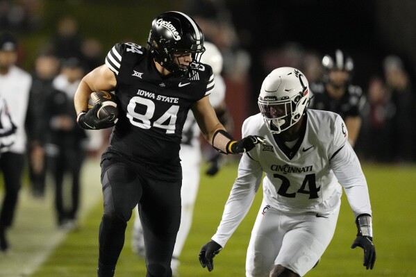Iowa State tight end Gabe Burkle (84) runs from Cincinnati defensive end Darian Varner (24) after catching a pass during the first half of an NCAA college football game, Saturday, Nov. 16, 2024, in Ames, Iowa. (AP Photo/Charlie Neibergall)