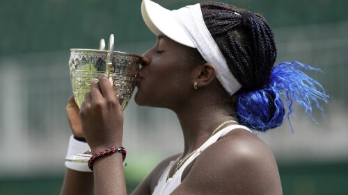 Clervie Ngounoue of the US celebrates with her trophy after beating Nikola Bartunkova of the Czech Republic in the girl's singles final on day fourteen of the Wimbledon tennis championships in London, Sunday, July 16, 2023. (AP Photo/Kin Cheung)