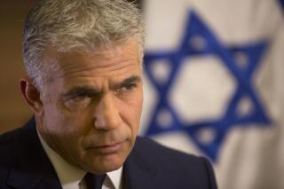 FILE - In this Oct. 31, 2016 file photo, Israeli Knesset member, Yair Lapid, gives an interview in his office at the Knesset, Israel's parliament, in Jerusalem. Lapid, the co-leader of Israel's opposition Blue and White party said Monday, Feb. 10, 2020, that President Donald Trump's Mideast plan offers a promising blueprint for resolving the Israeli-Palestinian conflict, but that Prime Minister Benjamin Netanyahu had turned it into a campaign “stunt” by pushing for immediate annexation of West Bank settlements. (AP Photo/Sebastian Scheiner, File)