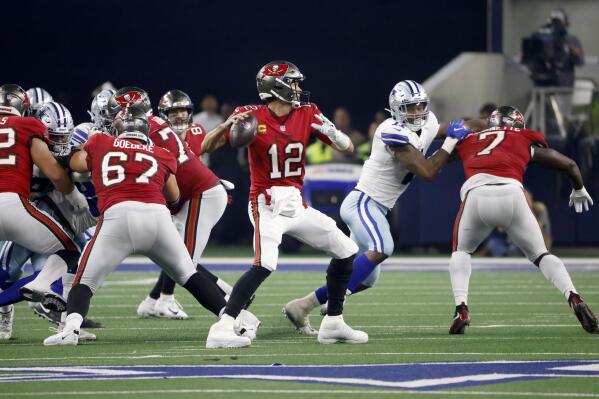 Tampa Bay Buccaneers quarterback Tom Brady (12) prepares to throw a pass as running back Leonard Fournette (7) helps against pressure from Dallas Cowboys linebacker Micah Parsons, second from right, in the second half of a NFL football game in Arlington, Texas, Sunday, Sept. 11, 2022. (AP Photo/Ron Jenkins)
