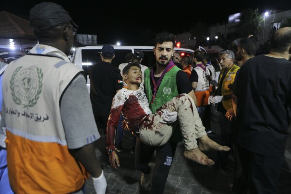 Wounded Palestinians arrive to al-Shifa hospital in Gaza City, central Gaza Strip, after arriving from al-Ahli hospital following an explosion there, Tuesday, Oct. 17, 2023. The Hamas-run Health Ministry says an Israeli airstrike caused the explosion that killed hundreds at al-Ahli, but the Israeli military says it was a misfired Palestinian rocket. (AP Photo/Abed Khaled)