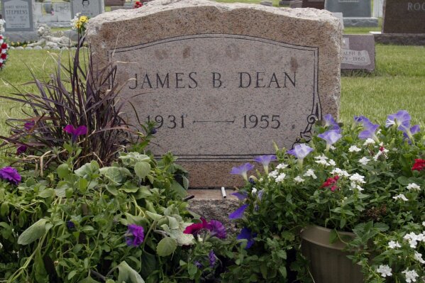 FILE - This May 27, 2005 file photo shows plants and flowers at the grave of actor James Dean in Fairmount, Ind. Dean hasn’t been alive in 64 years, but the “Rebel Without a Cause” actor has been cast in a new film about the Vietnam War. The filmmakers behind the independent film “Finding Jack” said Wednesday that a computer-generated Dean will play a co-starring role in the upcoming production. The digital Dean is to be assembled through old footage and photos and voiced by another actor. (AP Photo/John Harrell, File)