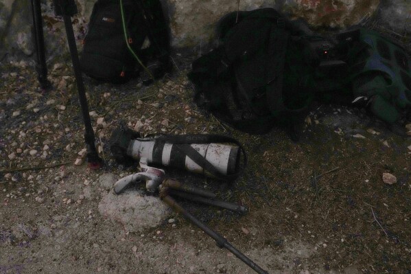 The camera of a photographer who was injured by Israeli shelling, is left on the ground at the Alma al-Shaab border village with Israel, south Lebanon, Friday, Oct. 13, 2023. An Israeli shell landed in a gathering of international journalists covering clashes on the border in south Lebanon, killing one and leaving six others injured. (AP Photo/Hassan Ammar)