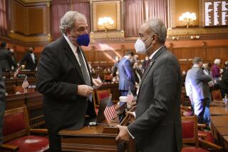 State Rep. Jonathan Steinberg, D-Westport, left, speaks with State Sen. Saud Anwar, D-South Windsor, during opening session at the State Capitol, Wednesday, Feb. 9, 2022, in Hartford, Conn. (AP Photo/Jessica Hill)