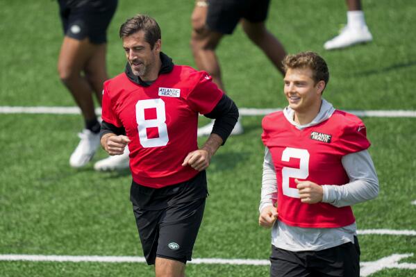 CORRECTS CITY AND STATE - New York Jets quarterback Aaron Rodgers (8) performs stretching drills with quarterback Zach Wilson (2) at the NFL football team's practice facility, Tuesday, May 23, 2023, in Florham Park, N.J. (AP Photo/John Minchillo)
