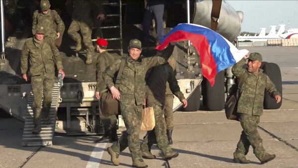 In this photo taken from video released by Russian Defense Ministry Press Service on Saturday, May 24, 2025, Russian servicemen leave a plane upon arrival to Chkalovsky airport, outside Moscow, Russia, after returning from captivity by a POWs exchange between Russia and Ukraine. (Russian Defense Ministry Press Service photo via AP)