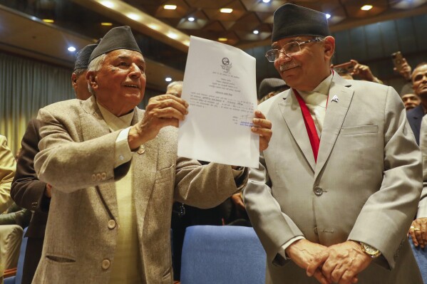 FILE- Nepalese Prime Minister Pushpa Kamal Dahal, right, looks on as Ram Chandra Poudel of the Nepali Congress party, left, shows his candidacy papers after filing his nomination to become Nepal's next president in Kathmandu, Nepal, Feb. 25, 2023. Dahal has ended his partnership with the Nepali Congress party, the largest group in parliament, and is now joining forces with the Communist Party of Nepal (Unified Marxist-Leninist), the second-biggest party led by Khadga Prasad Oli.(AP Photo/Bikram Rai, File)