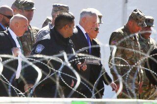 
              In this Nov. 14, 2018 photo, Secretary of Defense Jim Mattis and Homeland Security Secretary Kirsten Nielsen, third from the right, visit Base Camp Donna, in Donna, Texas. Mattis says the White House has given him the authority to use military troops to protect Customs and Border Protection personnel at the southwest border. This could, under certain circumstances, mean directing troops to temporarily detain migrants in the event of disorder or violence against border patrol agents.  (Joel Martinez/The Monitor via AP)/The Monitor via AP)
            