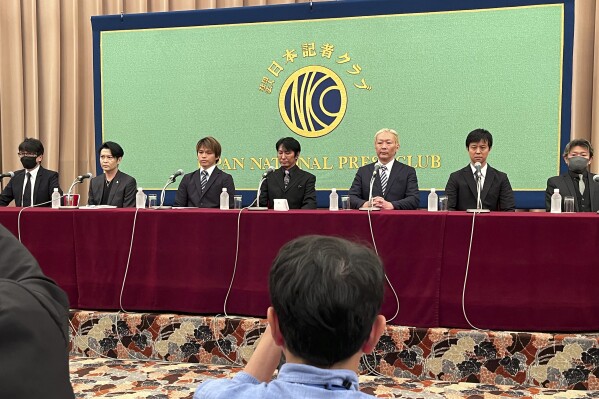 Seven men appear at a news conference on their talks with the U.N. Working Group on Business and Human Rights about the sexual abuse on children that allegedly happened at Johnny & Associates at the Japan National Press Club in Tokyo Friday, Aug. 4, 2023. From left, anonymous man who was identified by surname Hayashi, Yasunobu Shiga, Kazuya Nakamura, Junya Hiramoto, Shimon Ishimaru, Aiimasa Nihongi and another man who was identified only as Izumi. (AP Photo/Yuri Kageyama)