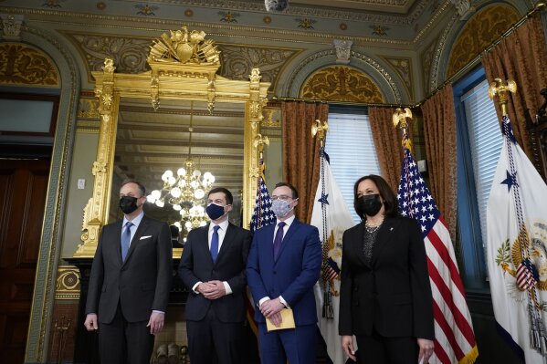 Pete Buttigieg, second left, after being sworn in as Transportation Secretary by Vice President Kamala Harris, right, in the Old Executive Office Building in the White House complex in Washington, Wednesday, Feb. 3, 2021, with Chasten Buttigieg, second right and Doug Emhoff, left. (AP Photo/Andrew Harnik)