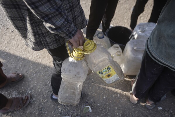 Palestinians displaced by the Israeli ground offensive on the Gaza Strip queue for water at a makeshift tent camp in Rafah, Gaza Strip, Monday, Feb. 19, 2024. (AP Photo/Mohammed Dahman)