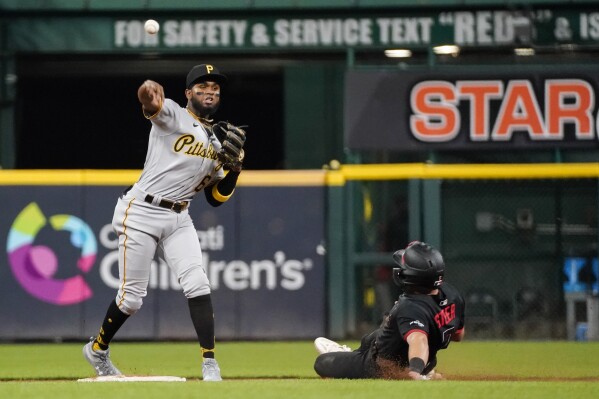 Pittsburgh Pirates shortstop Liover Peguero, left, forces out Cincinnati Reds' Spencer Steer, right, at second base and throws out Reds' Christian Encarnacion-Strand during the ninth inning of a baseball game, Friday, Sept. 22, 2023, in Cincinnati. (AP Photo/Joshua A. Bickel)