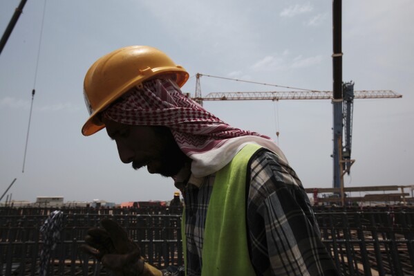 In this May 8, 2014, file photo a man works on construction of the Kingdom Tower, a planned 252-story building, which aims to become the world's tallest skyscraper when complete, in Jiddah, Saudi Arabia.(AP Photo/Hasan Jamali, File)