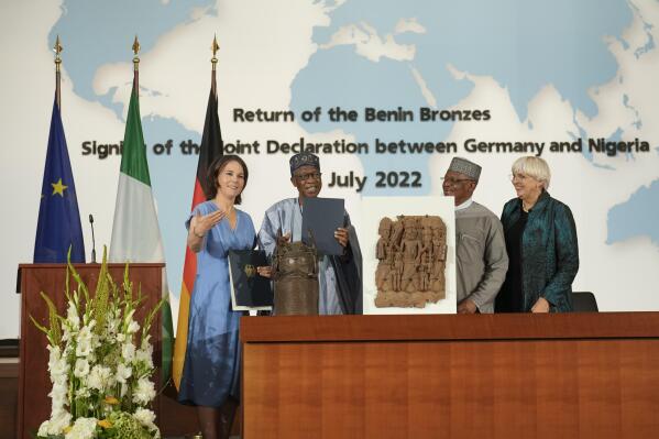 From left, German Foreign Minister Annalena Baerbock, Minister of Information and Culture of Nigeria Lai Mohammed, Nigerian Minister of State of Foreign Affairs Zubairo Dada and German Government Commissioner for Culture and the Media Claudia Roth pose for the media near two Benin Bronze sculptures after signing an agreement in Berlin, Germany, Friday, July 1, 2022. Germany and Nigeria signed an agreement in Berlin Friday paving the way for the return of centuries-old sculptures known as the Benin Bronzes that were taken from Africa in the 19th century and displayed in German museums and elsewhere. (AP Photo/Markus Schreiber)