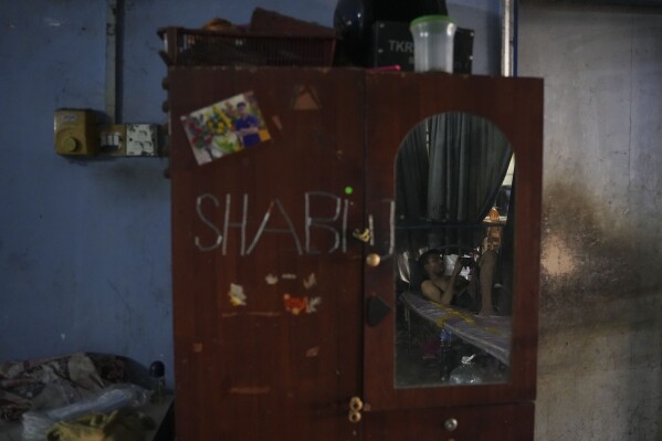 A Bangladeshi migrant worker rests on a dormitory bed in Klang, Malaysia, Friday, Jan. 24, 2025. (AP Photo/Azneal Ishak)