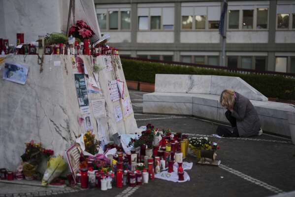A woman prays next to the statue of Pope John Paul II, outside the Agostino Gemelli Polyclinic, where the Pope Francis is being treated for pneumonia, in Rome, Monday, March 10, 2025. (AP Photo/Francisco Seco)