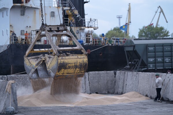 FILE - Workers load grain at a grain port in Izmail, Ukraine, on April 26, 2023. Russia has repeatedly fired missiles and drones at Ukrainian ports key to sending grain to the world. Moscow has declared large swaths of the Black Sea dangerous for shipping. (AP Photo/Andrew Kravchenko, File)