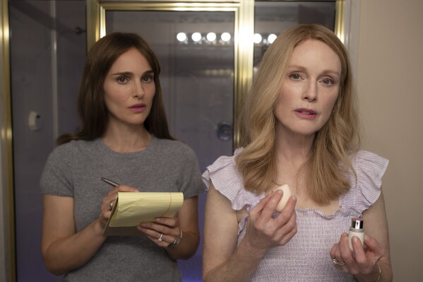 This image released by Netflix shows Julianne Moore, right, and Natalie Portman in a scene from "May December." (François Duhamel, Netflix via AP)