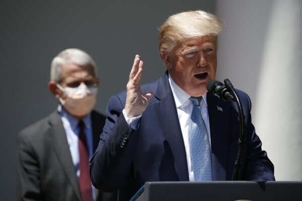 President Donald Trump speaks about the coronavirus in the Rose Garden of the White House, Friday, May 15, 2020, in Washington. Director of the National Institute of Allergy and Infectious Diseases Dr. Anthony Fauci listens at left. (AP Photo/Alex Brandon)