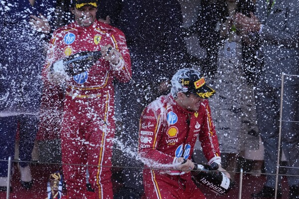2024年5月26日，星期日，摩纳哥，法拉利车手查尔斯·勒克莱尔（右）在摩纳哥赛道赢得一级方程式摩纳哥大奖赛后，在领奖台上庆祝。（美联社照片/卢卡·布鲁诺）
