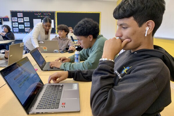 Bryan Martinez, a senior at Capital City Public Charter School in Washington, works on a computer during his Advanced Algebra with Financial Applications class on Sept. 12, 2023. For his medium-term financial goals, he settles on a car — he doesn’t have one yet — and vacations. Peering way into his future, the 18-year-old also imagines saving money to buy a house, start his own business, retire, and perhaps provide any children with a college fund. (Jackie Valley/The Christian Science Monitor via AP)