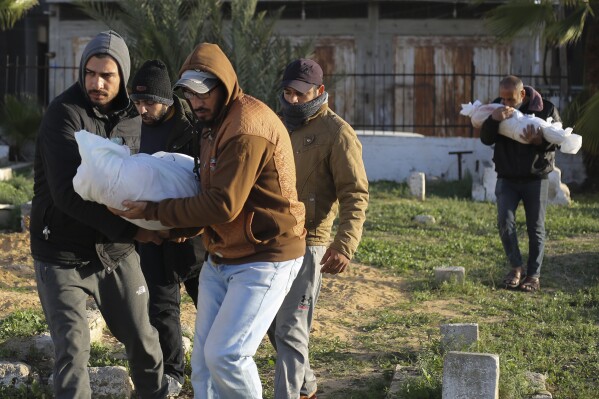 I palestinesi trasportano i corpi della famiglia Thayer uccisa in un bombardamento israeliano nella Striscia di Gaza durante un funerale a Rafah, venerdì 22 dicembre 2023.  (AP Photo/Hatem Ali)