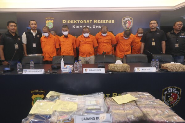 Indonesian police officers escort suspects and display the items of evidence during a press conference at Jakarta police headquarters in Jakarta, Indonesia, Thursday, July 20, 2023. Indonesian police are investigating an illegal trade in human organs involving a police and an immigration officers who were accused of helping traffickers send 122 Indonesians to a hospital in Cambodia to sell their kidneys, police said.(AP Photo)