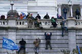 Supporters of President Donald Trump climb the West wall of the the U.S. Capitol on Wednesday, Jan. 6, 2021, in Washington. (AP Photo/Jose Luis Magana)