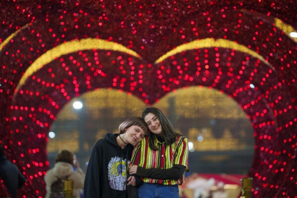 A couple waits for their turn in a mock marriage ceremony dubbed "Married for one day" during a Valentine's Day event in Bucharest, Romania, Tuesday, Feb. 13, 2024. (AP Photo/Andreea Alexandru)