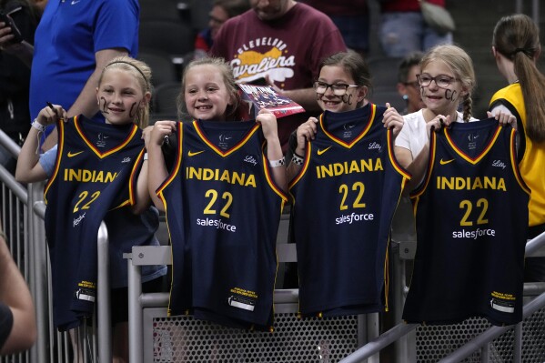 Fans watch Indiana Fever guard Caitlin Clark warm up for the team's WNBA basketball game against the New York Liberty, Thursday, May 16, 2024, in Indianapolis. (AP Photo/Michael Conroy)