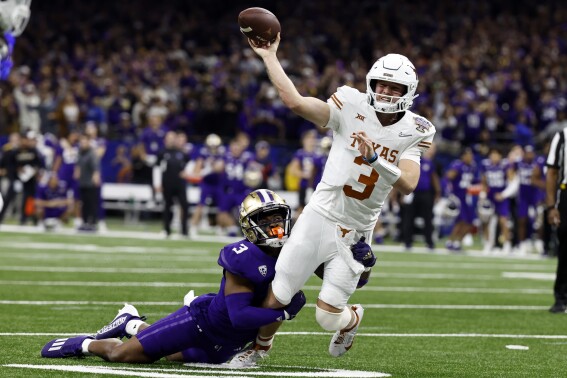 FILE - Texas quarterback Quinn Ewers (3) is tackled by Washington safety Mishael Powell (3) as he throws the ball during the second half of an NCAA college football game Monday, Jan. 1, 2024, in New Orleans. The Longhorns wrap spring practice this week looking forward to Ewers leading them into the 2024 season and their move into the Southeastern Conference. The NFL remains Ewers' dream but can wait a year. (AP Photo/Butch Dill, File)