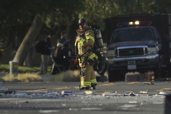Firefighters stand at the scene of the explosion in Palm Springs, California on Saturday, May 17, 2025 (AP Photo/Eric Thayer)