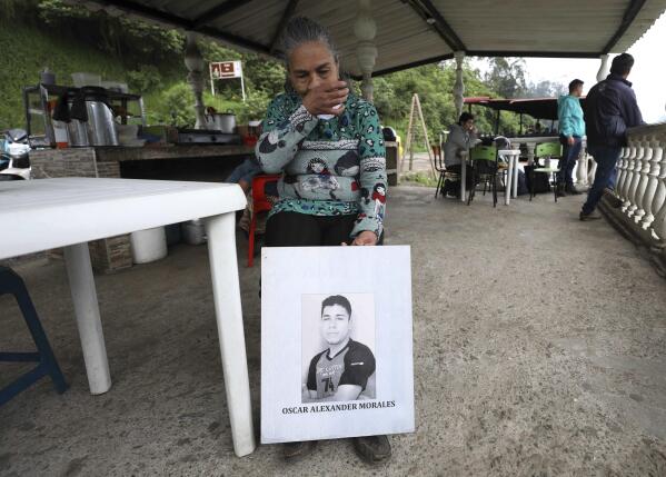 Doris Tejada, mother of Oscar Alexander Morales who disappeared on New Year's eve 2007, holds a photo of her son, at a shop in Soacha, Colombia, Thursday, April 8, 2021. Tejada and her husband found out that their son indeed is on the list of the "false positives," victims of extrajudicial executions by members of Colombia's army who were falsely presented as guerrillas killed in combat during the country's internal conflict, which ended with the 2016 demobilization of the Revolutionary Armed Forces of Colombia. (AP Photo/Fernando Vergara)