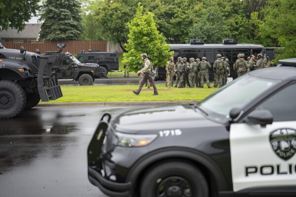 Law enforcement officers including local police, sheriffs and the FBI, stage less than a mile from a shooting in Brooklyn Park, Minn. on Saturday, June 14, 2025. (Alex Kormann/Star Tribune via AP)